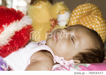 Close up face of cute sleeping newborn baby boy in drowsy eyes sleepy mood lying on bed. Portrait One Sweet little infant toddler. Indian ethnicity. Front view. Child care peace tranquil background. Close up face of cute sleeping newborn baby boy in drowsy eyes sleepy mood lying on bed. Portrait One Sweet little infant toddler. Indian ethnicity. Front view. Child care peace tranquil background. 76856437