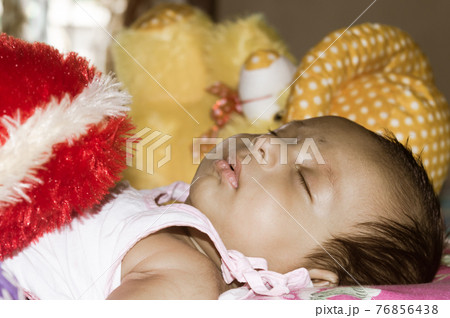 Close up face of cute sleeping newborn baby boy in drowsy eyes sleepy mood lying on bed. Portrait One Sweet little infant toddler. Indian ethnicity. Front view. Child care peace tranquil background. Close up face of cute sleeping newborn baby boy in drowsy eyes sleepy mood lying on bed. Portrait One Sweet little infant toddler. Indian ethnicity. Front view. Child care peace tranquil background. 76856438