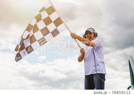 Man waves a checkered flag 76858112