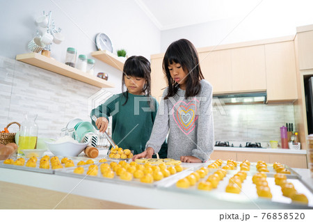 two little girl making nastar tart cake together two little girl making nastar tart cake together 76858520