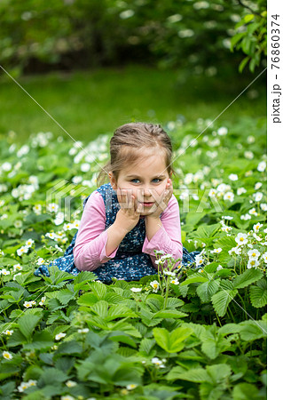 Strawberry flowerchild in a blooming strawberry 76860374