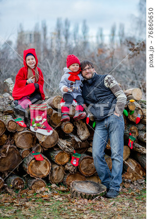 Happy children with father play and eat cookies outdoors. Children play outside on a frosty day. 76860650