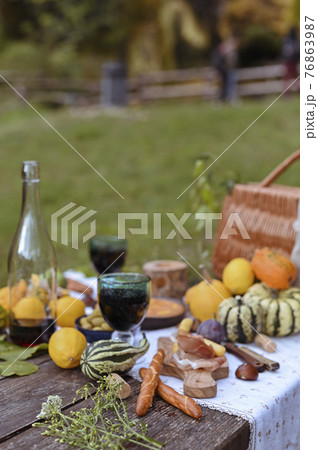 Table prepared for lunch in autumn nature, picnic . Harvest, autumn lunch, Wine and glasses. Outdoor Table prepared for lunch in autumn nature, picnic . Harvest, autumn lunch, Wine and glasses. Outdoor 76863987