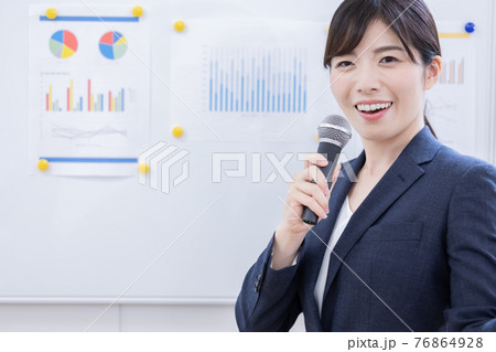 ビジネス　マイクを持ってプレゼンする女性 76864928