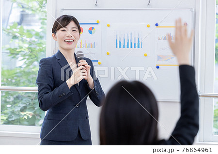 ビジネス マイクを持ってプレゼンする女性 ビジネス マイクを持ってプレゼンする女性 76864961