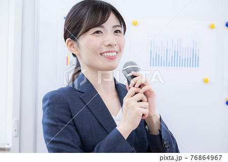 ビジネス マイクを持ってプレゼンする女性 ビジネス マイクを持ってプレゼンする女性 76864967