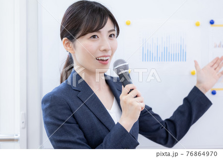 ビジネス　マイクを持ってプレゼンする女性 76864970