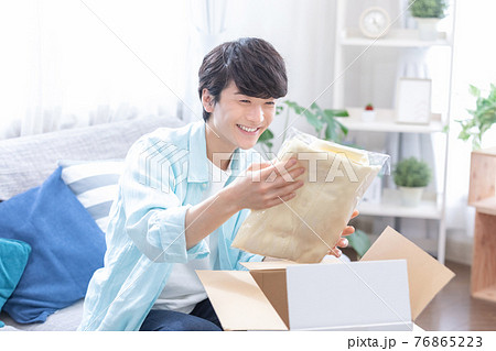 ライフスタイル 通信販売 届いた商品を開封する若い男性 ライフスタイル 通信販売 届いた商品を開封する若い男性 76865223