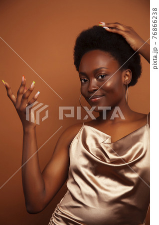 pretty young african american woman with curly hair posing cheerful gesturing on brown background, lifestyle people concept pretty young african american woman with curly hair posing cheerful gesturing on brown background, lifestyle people concept 76866238
