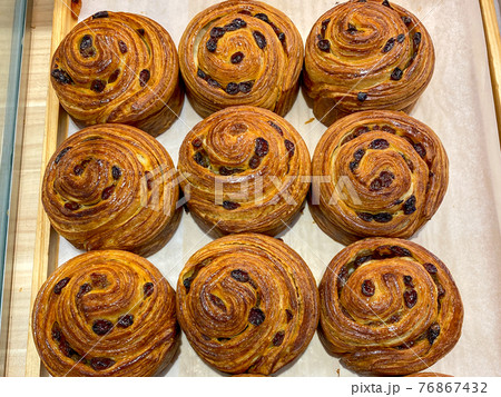 Fresh-baked raisin croissants for sale at pastry shop Fresh-baked raisin croissants for sale at pastry shop 76867432