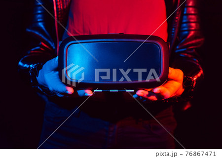Virtual reality glasses in women's hands. The concept of modern and futuristic technologies Virtual reality glasses in women's hands. The concept of modern and futuristic technologies 76867471
