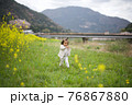 春の菜の花と桜と子供 76867880