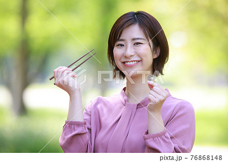 500円硬貨と箸を持つ女性社員　ワンコインランチイメージ 76868148