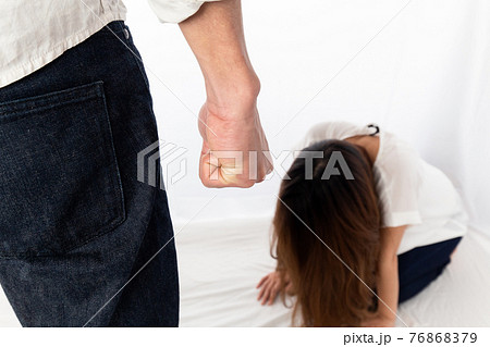 拳を握る男性に怯える女性 76868379