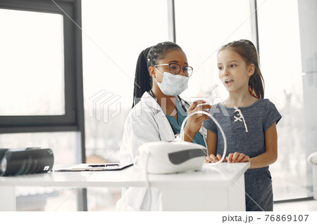 Doctor makes a procedure for a little girl Doctor makes a procedure for a little girl 76869107