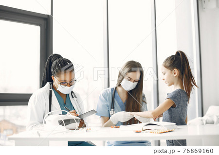 Doctor examines a little girl in hospital Doctor examines a little girl in hospital 76869160