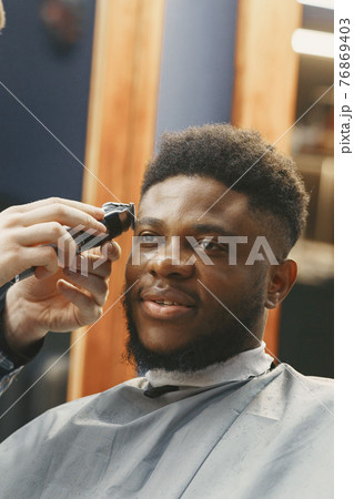 Young African-american man visiting barbershop 76869403