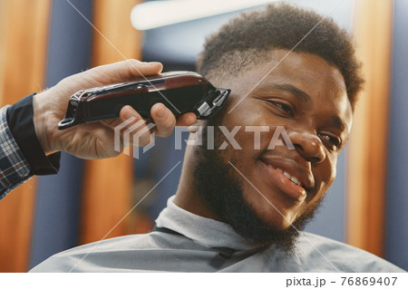 Young African-american man visiting barbershop 76869407