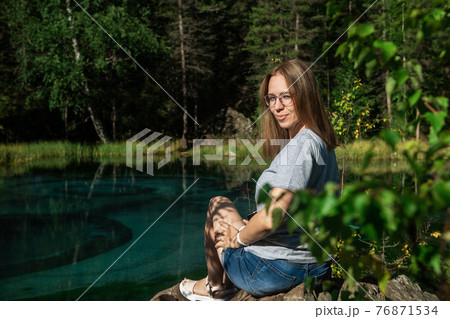 Woman resting at mountain lake in summer Woman resting at mountain lake in summer 76871534