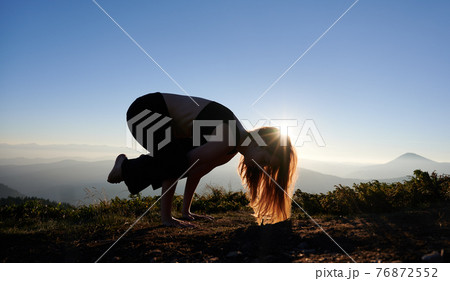 Young woman practicing yoga during sunset in mountains. Young woman practicing yoga during sunset in mountains. 76872552