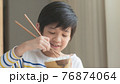Cute Asian boy eating rice with chopsticks 76874064