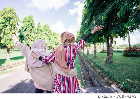Two friends muslim enjoying the summer sun 76874245