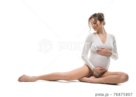 Graceful pregnant woman in white bodysuit relax on background Graceful pregnant woman in white bodysuit relax on background 76875807
