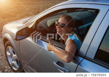 travel by car. Happy girl with glasses looks out of the car travel by car. Happy girl with glasses looks out of the car 76876004