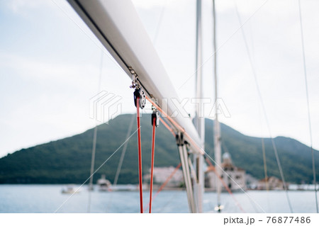 Winch of white sailing yacht with a red rope on a background of mountains 76877486