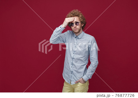 Portrait of elegant young man in sunglasses on red background Portrait of elegant young man in sunglasses on red background 76877726