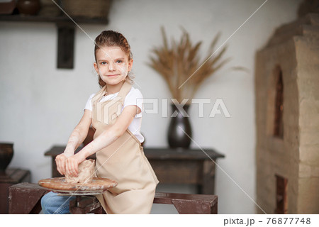 Charming craftsman little girl enjoying pottery art and producti 76877748