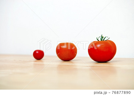 Studio Shot of three cherry tomatoes in a row Studio Shot of three cherry tomatoes in a row 76877890