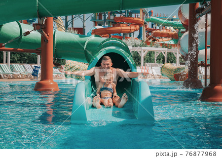 Father playing with his daughter in swimming pool. Funny family weekend. Father and daughter enjoy time together in water park. Father playing with his daughter in swimming pool. Funny family weekend. Father and daughter enjoy time together in water park. 76877968