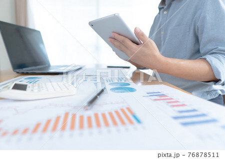 Businessman in casual wear stands beside desk to work at home with taplat. work from home. 76878511