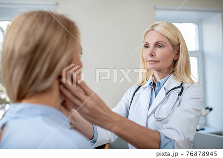 Doctor touching patients neck with his hands 76878945