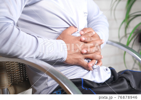 young man suffering stomach pain close up. young man suffering stomach pain close up. 76878946