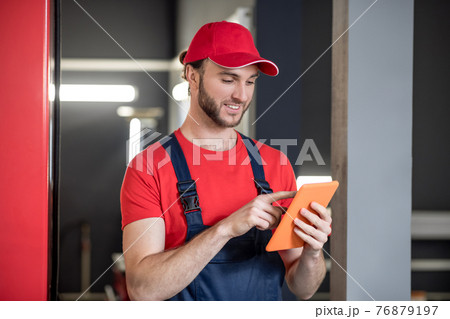 Man looking at tablet in car repair shop Man looking at tablet in car repair shop 76879197