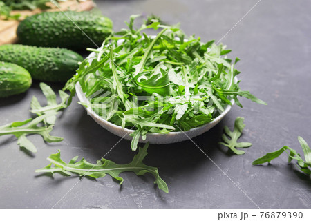 Fresh arugula leaves in bowl on dark table.Fresh vegeterian food concept 76879390