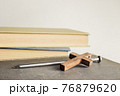 A cross with nail with bible over a light background.  76879620