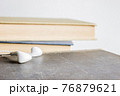 An earphone with books over the light background. 76879621