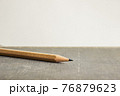 A sharp pencil over book with a light background.  76879623