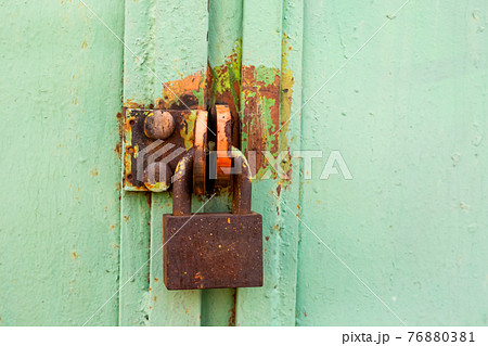 rusty padlock on green gate background close up, property protection 76880381