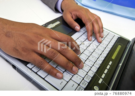 Close up of Indian mans hands typing on laptop 76880974