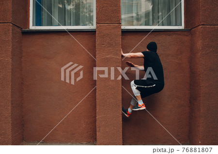 Young sporty guy doing parkour at the city street. 76881807