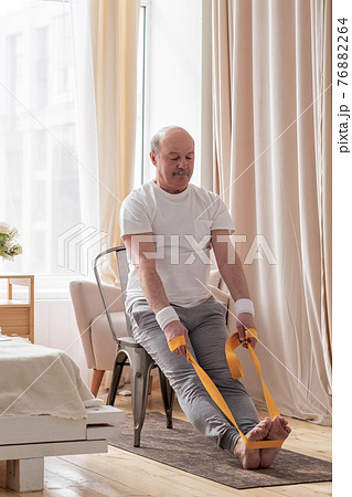 Man sitting on chair doing paschimottanasana or Intense Dorsal Stretch pose 76882264
