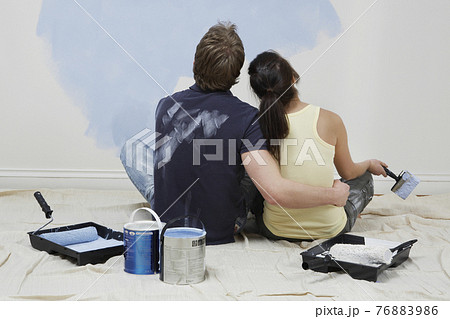 Rear View Of Couple Looking At Paint On Wall Rear View Of Couple Looking At Paint On Wall 76883986