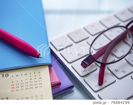 ビジネスイメージ・キーボード・カレンダー・メガネ・手帳・女性 76884299