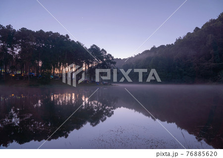 Fog or mist on river lake with forest trees in Pang Ung reservoir, Mae Hong Son, Thailand. Tourist attraction, surrounded by green pine, mountains, reflection from water. Fog or mist on river lake with forest trees in Pang Ung reservoir, Mae Hong Son, Thailand. Tourist attraction, surrounded by green pine, mountains, reflection from water. 76885620
