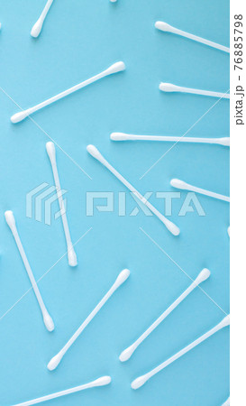 Pattern of white plastic cotton swabs top view on blue background Pattern of white plastic cotton swabs top view on blue background 76885798