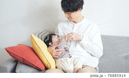 1歳の男の子に授乳するイクメン男性の写真素材